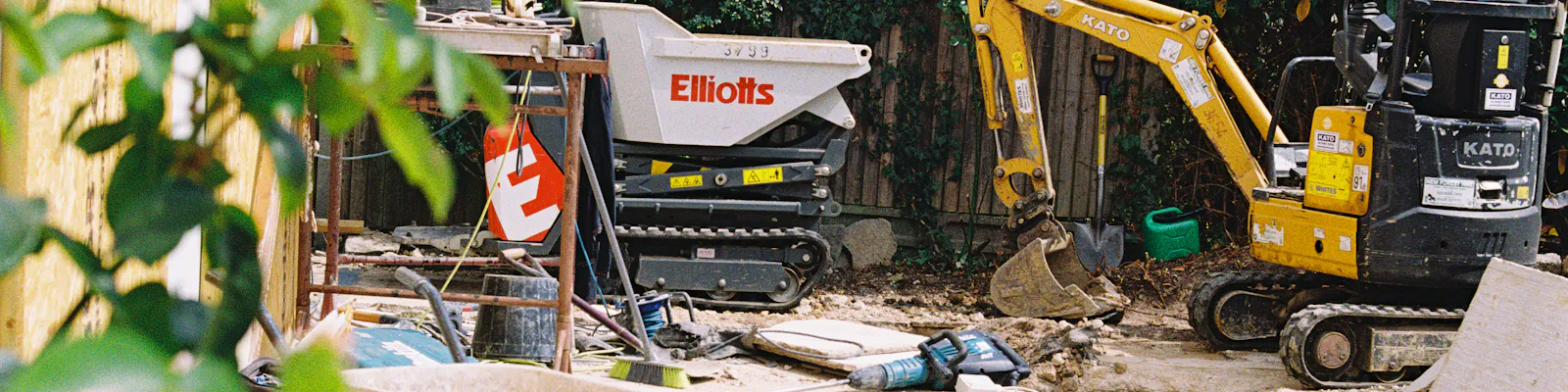 A mini excavator and dumper digging out ground on a building site